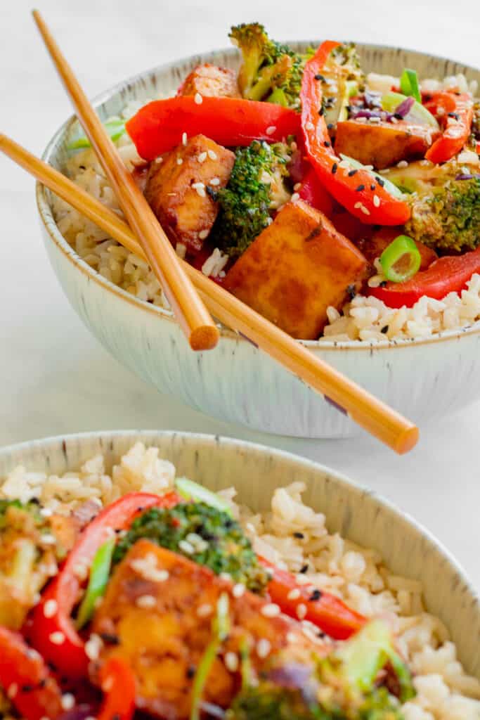 Two bowls of Crispy Tofu Hoisin Stir-fry in with chopsticks. Vegan, GF & Healthy! Georgie Eats.