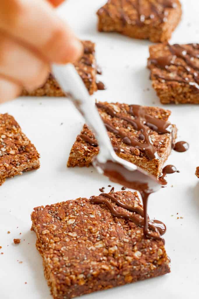 Drizzling melted chocolate over the chocolate flapjacks. Vegan, GF & healthy. Georgie Eats.