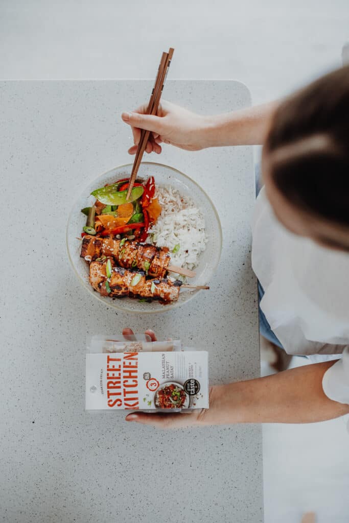 Overhead shot of rainbow Stir-fry with satay tofu skewers and Street Kitchen package.