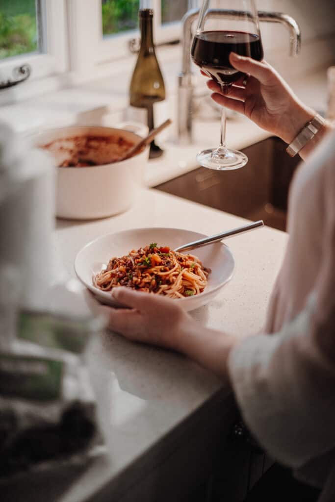 Enjoying the Best Ever Lentil Bolognese with a glass of red wine - Vegan, GF & Healthy! Georgie Eats.