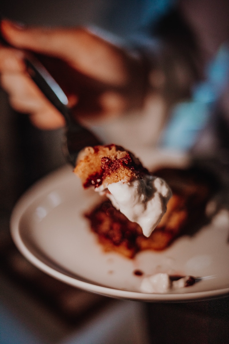 A forkful of blackberry bakewell bar with yoghurt