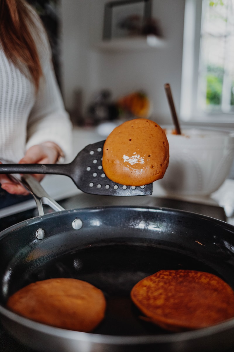 flipping the pumpkin pancakes in a pan
