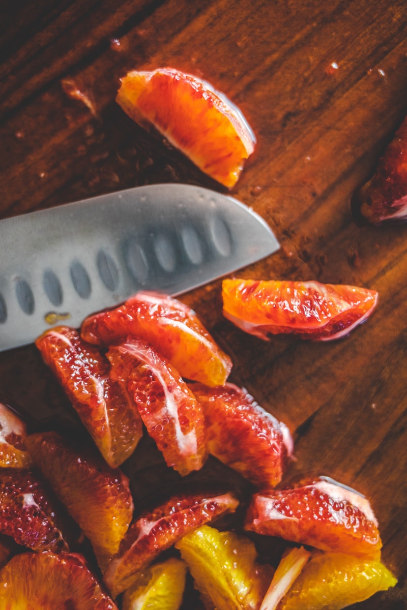 blood oranges on a board with a knife