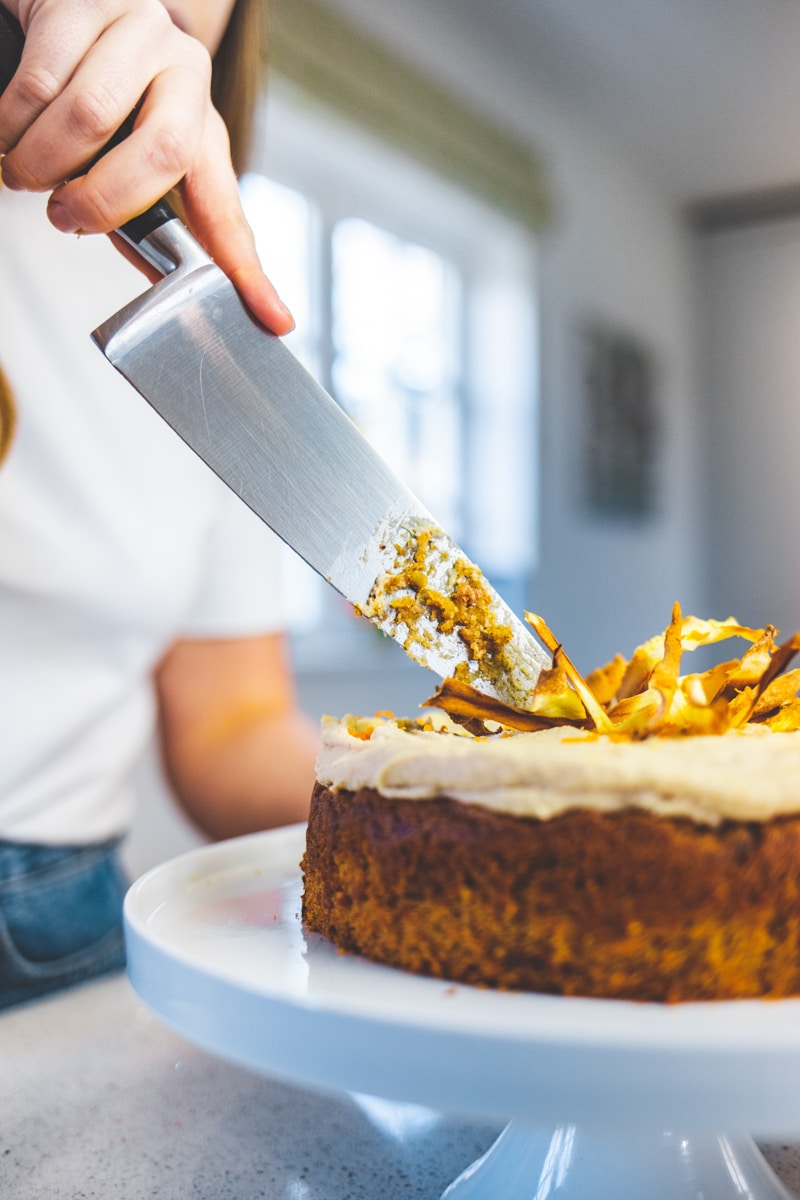 Cutting the Spiced Parsnip Cake with Vanilla Cashew Frosting - Georgie Eats