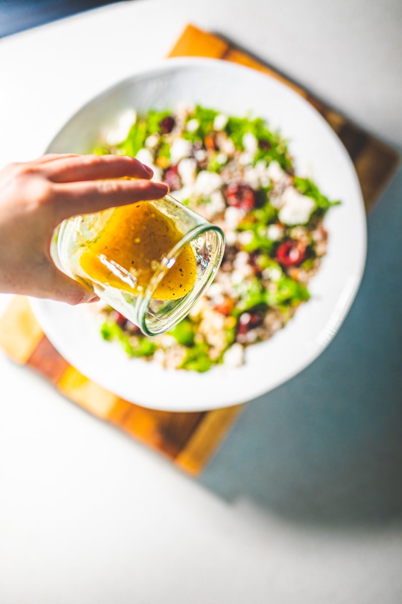 pouring dressing over Buckwheat & Cherry Salad - Georgie Eats